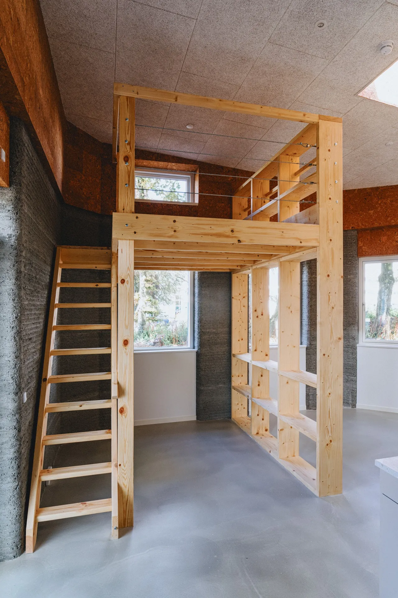 Finished interior with timber storage and a ladder to the loft