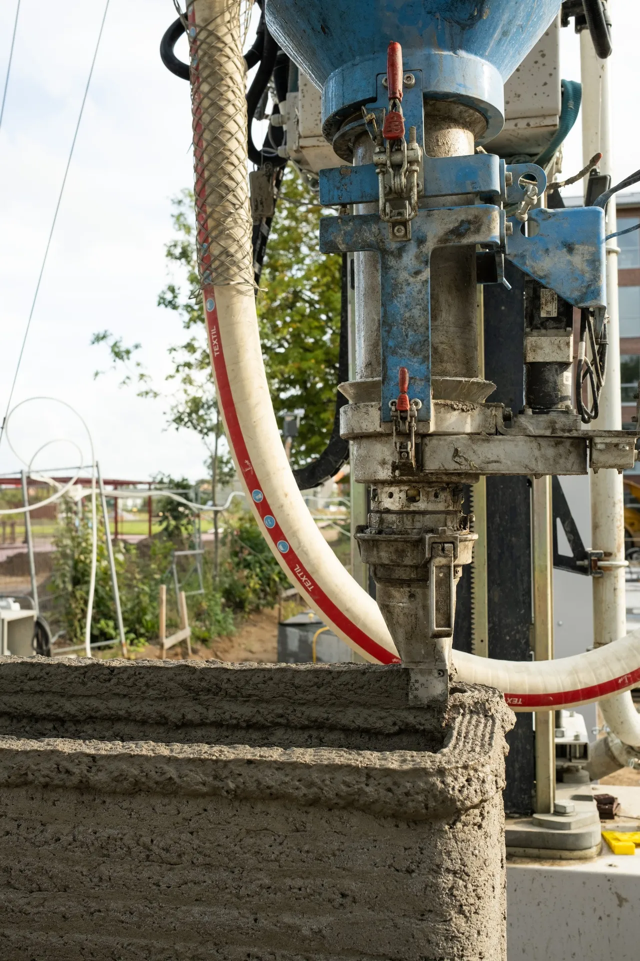 Print nozzle placing concrete layers during construction